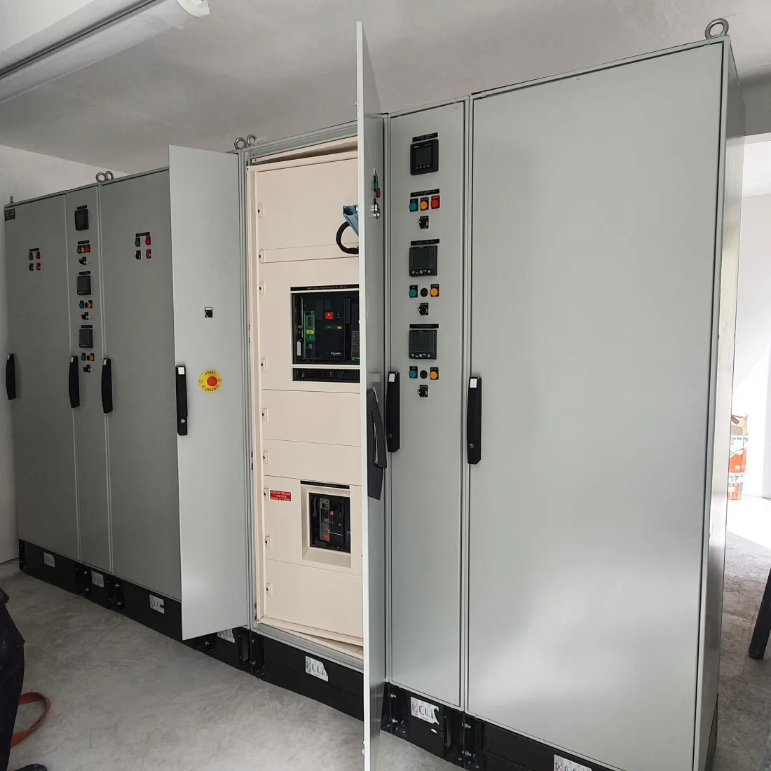 Armoires électriques de type Schneider Electric dans un local technique